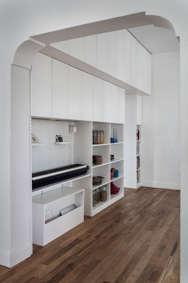 Avenues project — floor-to-ceiling white storage unit with piano nook and open shelving