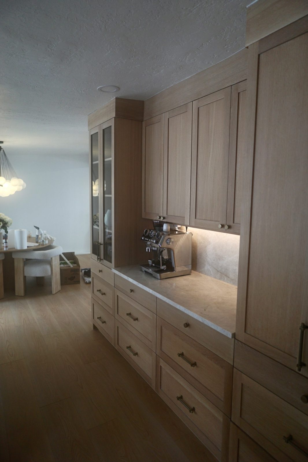 Canyon Rim coffee bar — white oak cabinetry with brass hardware and under-cabinet lighting