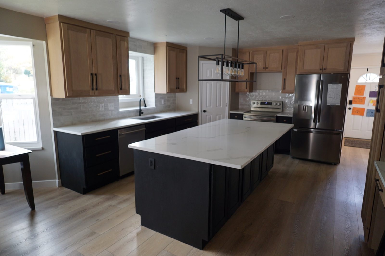 Centerville kitchen — dark base cabinets with natural wood uppers, quartz countertops