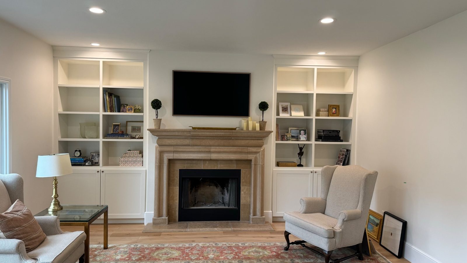Dalton living room — white painted built-in bookshelves flanking stone fireplace