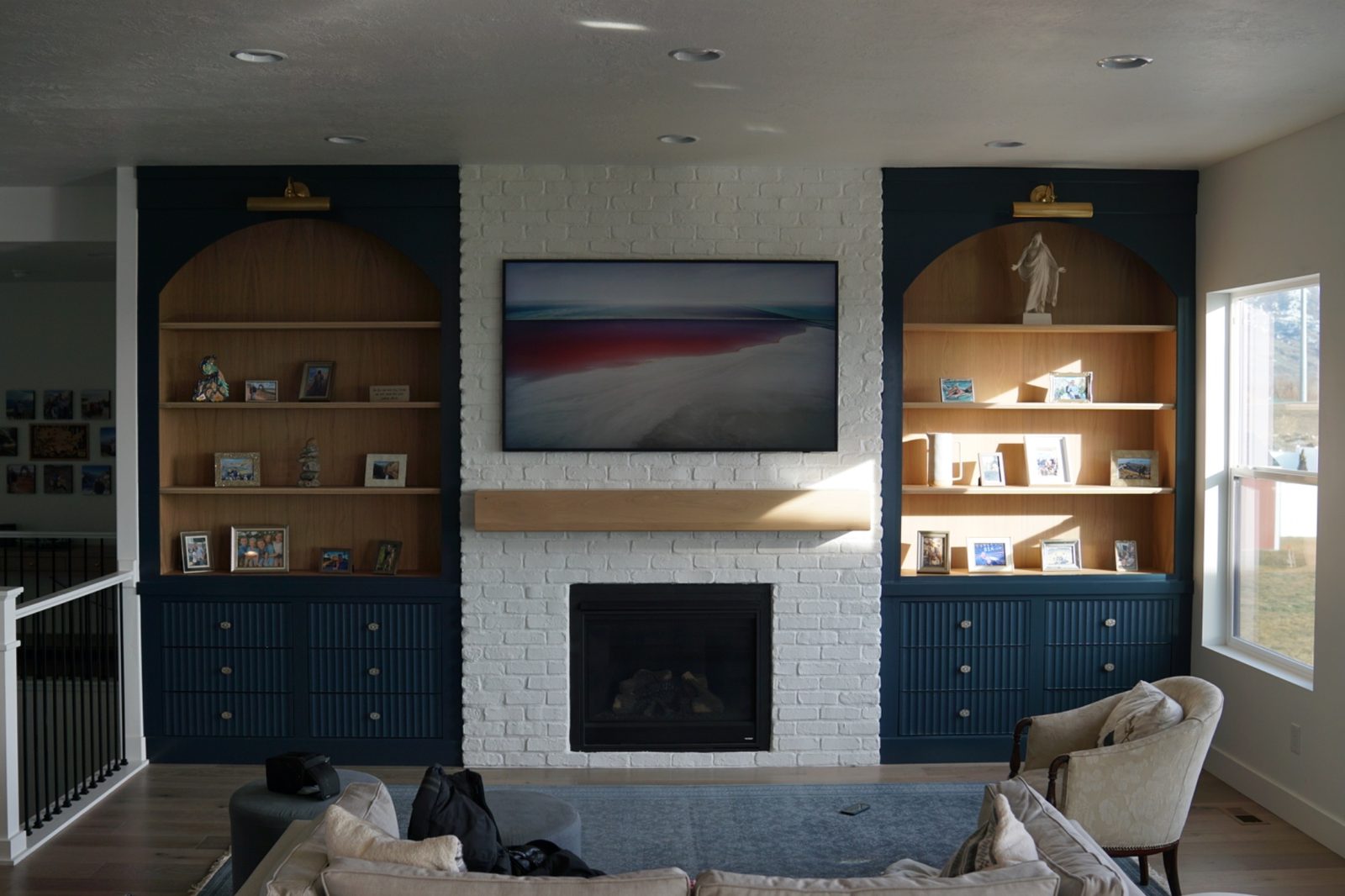 Built-in arched bookshelves with deep teal and natural wood — Farmington